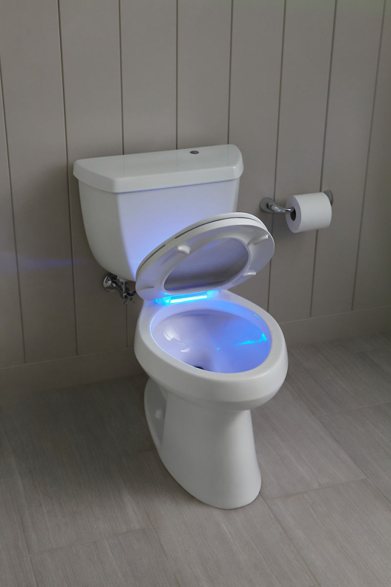 Une toilette blanche avec couvercle ouvert pour révéler un siège de toilette éclairé.