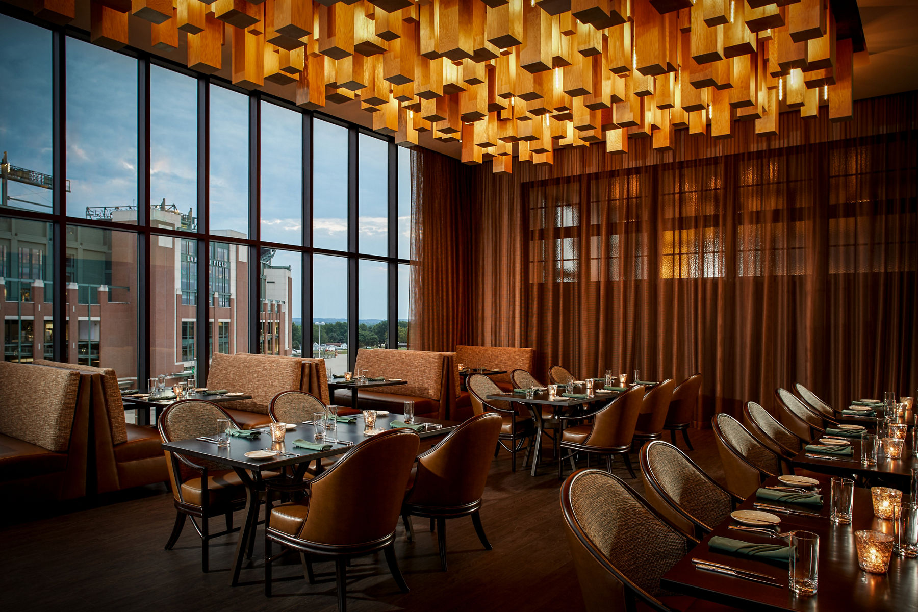 Photo of elegant dining room at Lodge Kohler with window view of stadium.