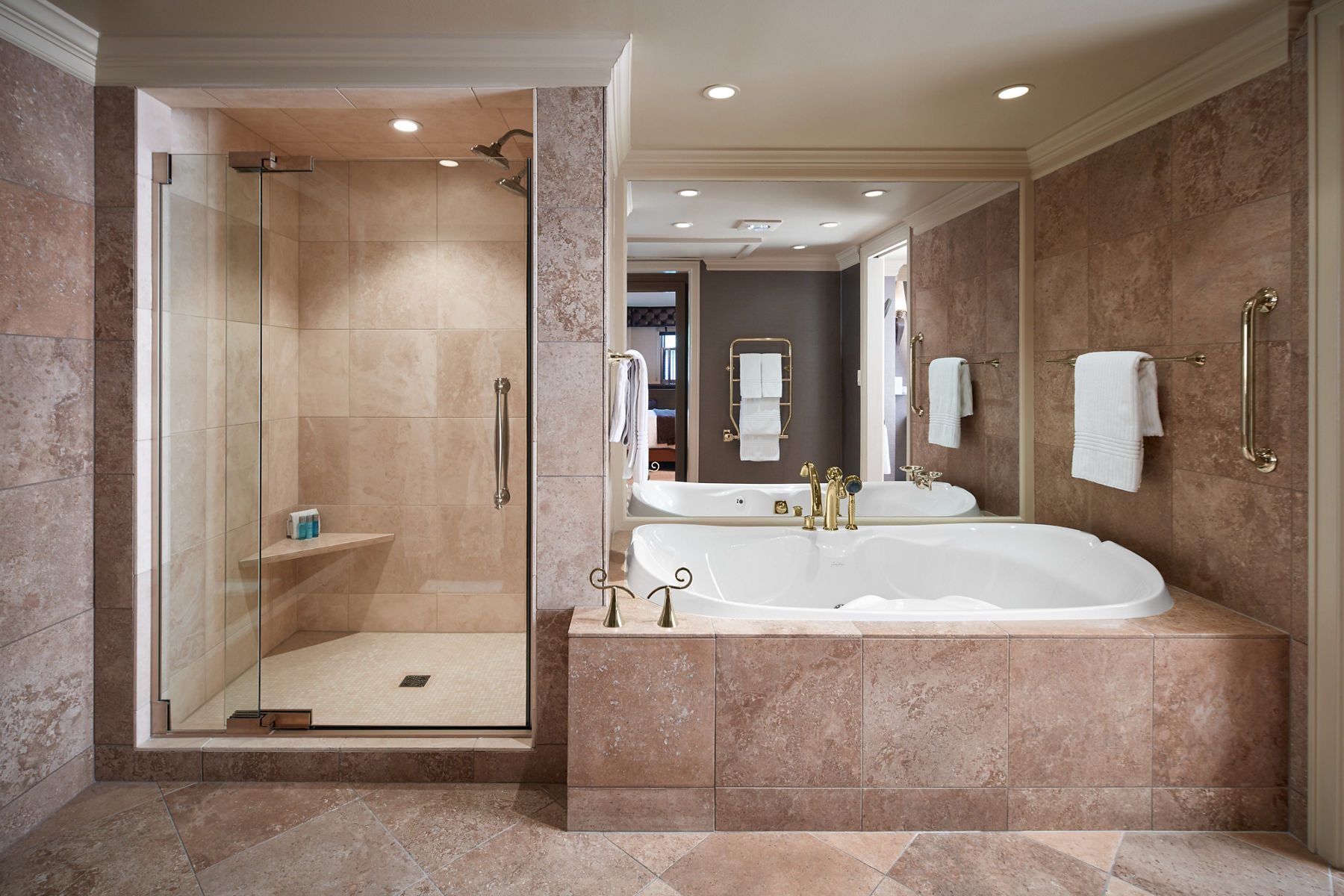 View of bathroom in Govenor’s Suite at the American Club featuring large, enclosed shower with glass door adjacent to large bath.