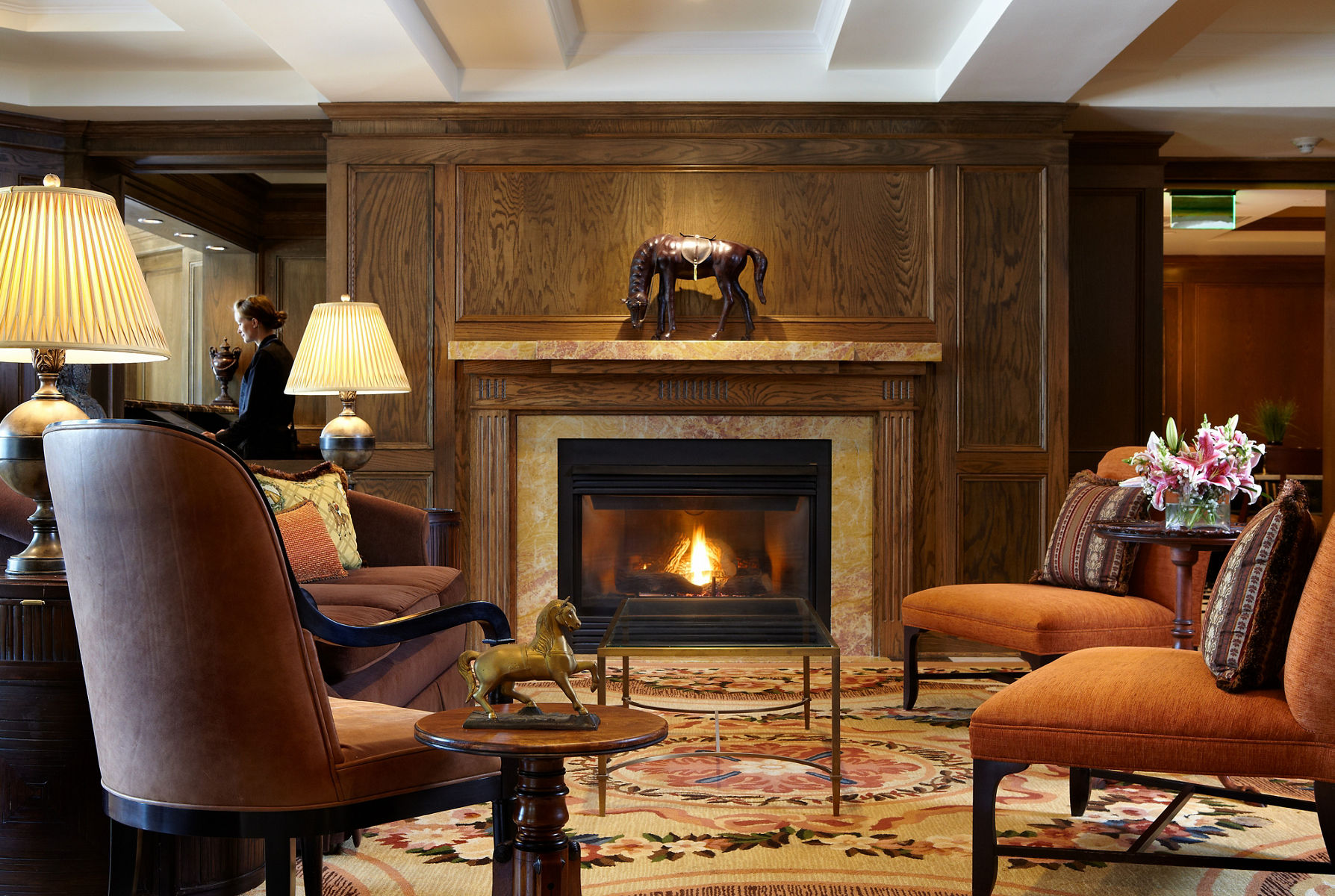 View of nicely decorated lobby area with comfortable seating and fireplace lit.