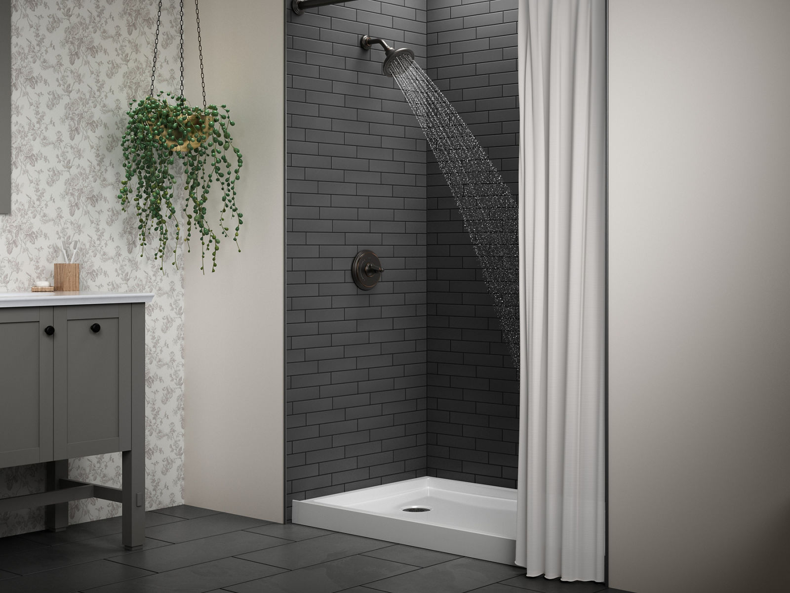 An acrylic shower base in a shower area with dark gray floor and wall tiles and black grout.
