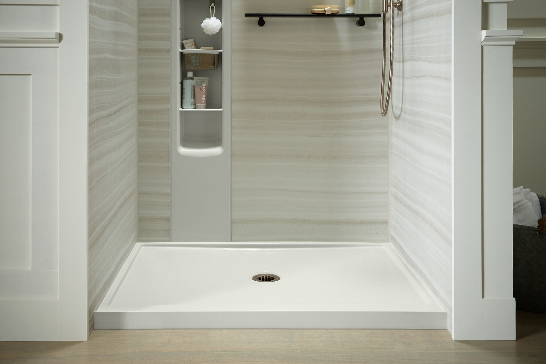 Base de douche Rely KOHLER avec drain central et couvercle de drain rond en bronze brossé vibrant.