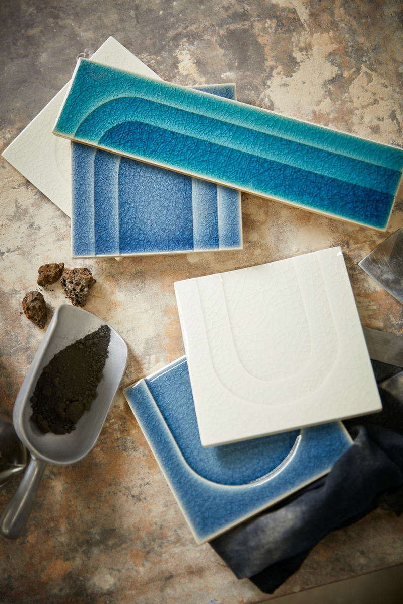 Carreaux posés sur une table dans différentes teintes de bleu et un carrelage au fini os.