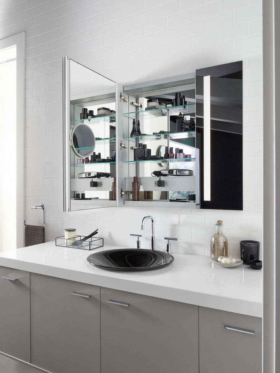 A medicine cabinet with the door open to show its mirror interior surfaces.
