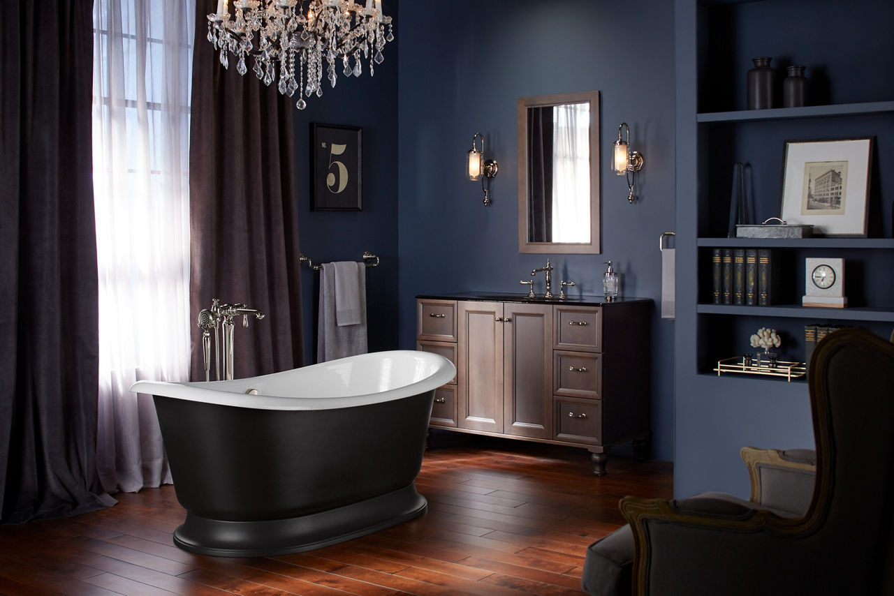 A bathroom in shades of dark indigo with an Artifacts freestanding cast iron bath with a white enameled interior and black exterior in the center.