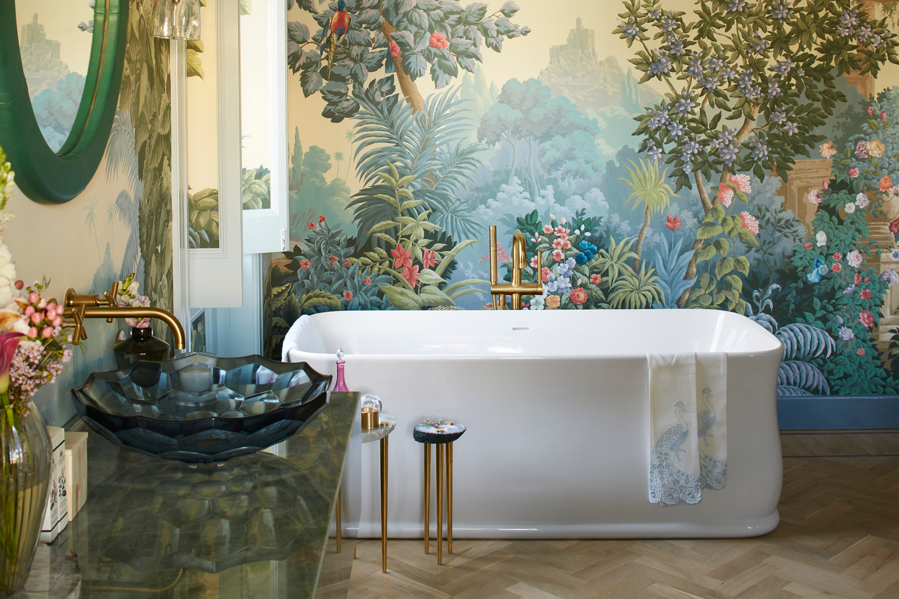 A romantic bathroom with a landscape mural, white KOHLER freestanding bath, Artist Editions Briolette glass sink, and Purist faucet and tub filler.