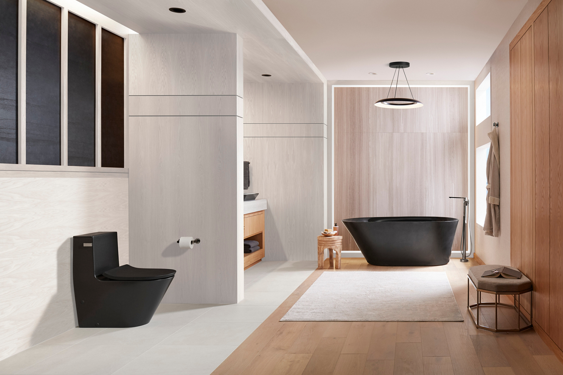 A modern bathroom in off-white and light natural wood tones with honed black Brazn collection products.