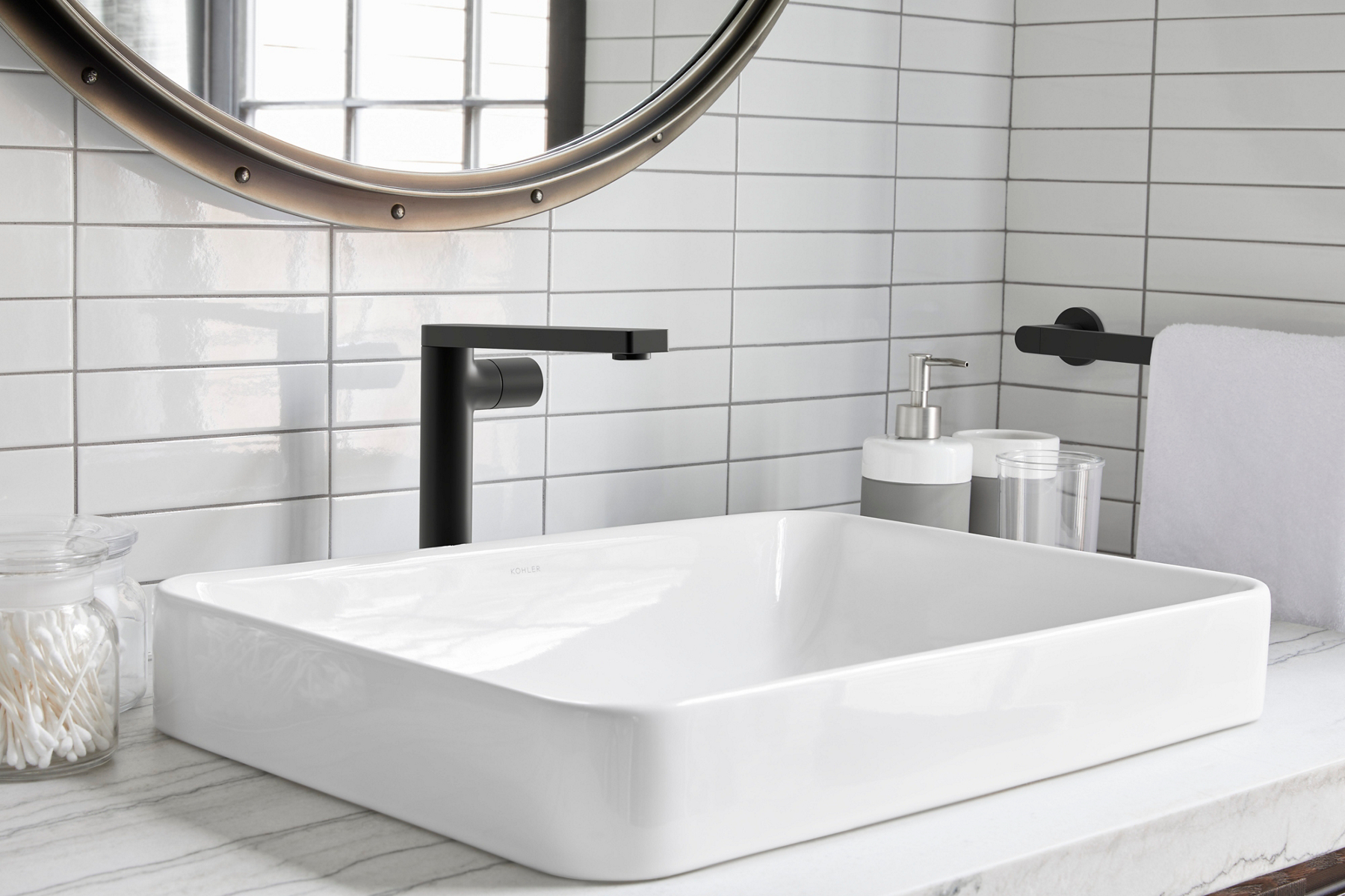 A black KOHLER Composed single handle faucet contrasts with a white Vox rectangle vessel sink and white rectangle tile backsplash.