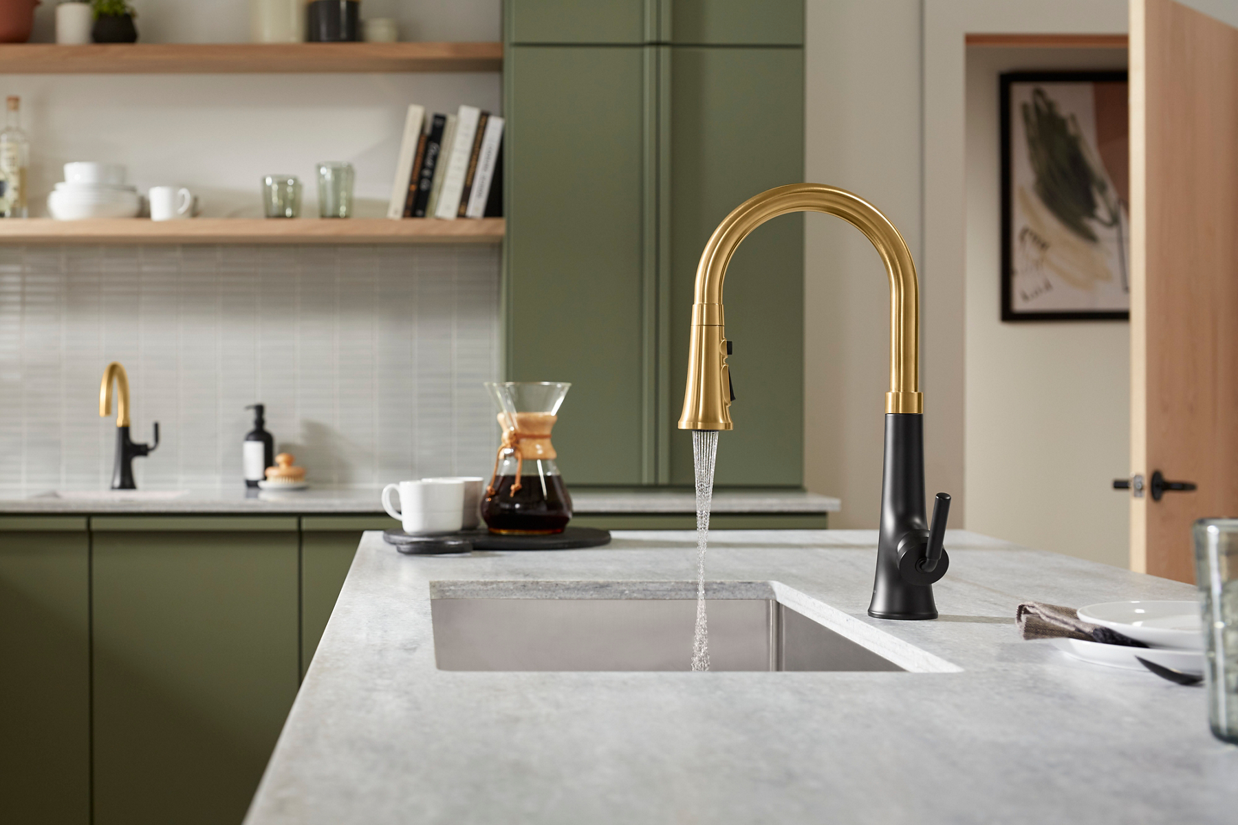 A side view of water flowing from a KOHLER Tone kitchen faucet with single lever handle, into a Strive undermount sink.