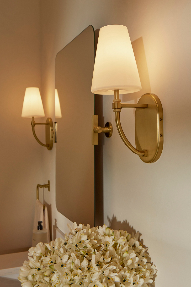 Image of two  brass lighting sconces with neutral tone mini-lamp shade designed by Shea McGee. 