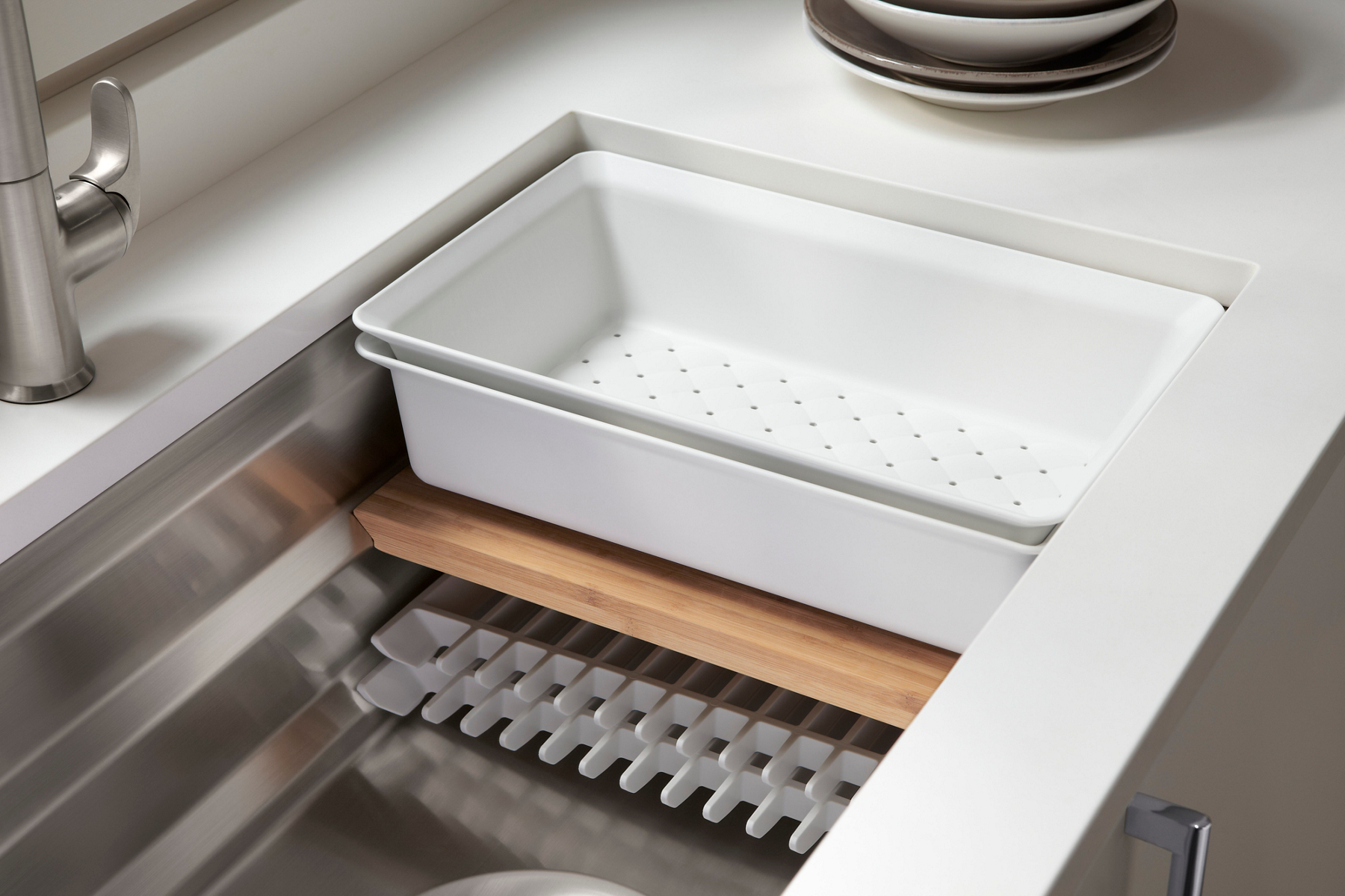 A KOHLER Prolific sink, outfitted with sliding bin, colander, cutting board and drain grates.
