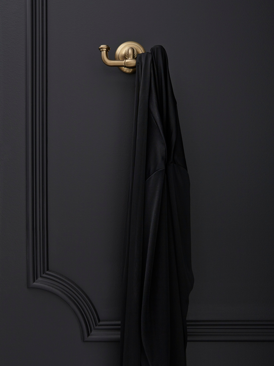 A black towel hangs from a KOHLER double robe hook in brushed nickel.